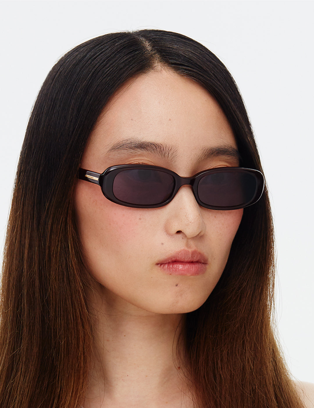 Side profile shot of model wearing the Aurora eco cherry red sunglasses with a slim rectangular frame and dark lens