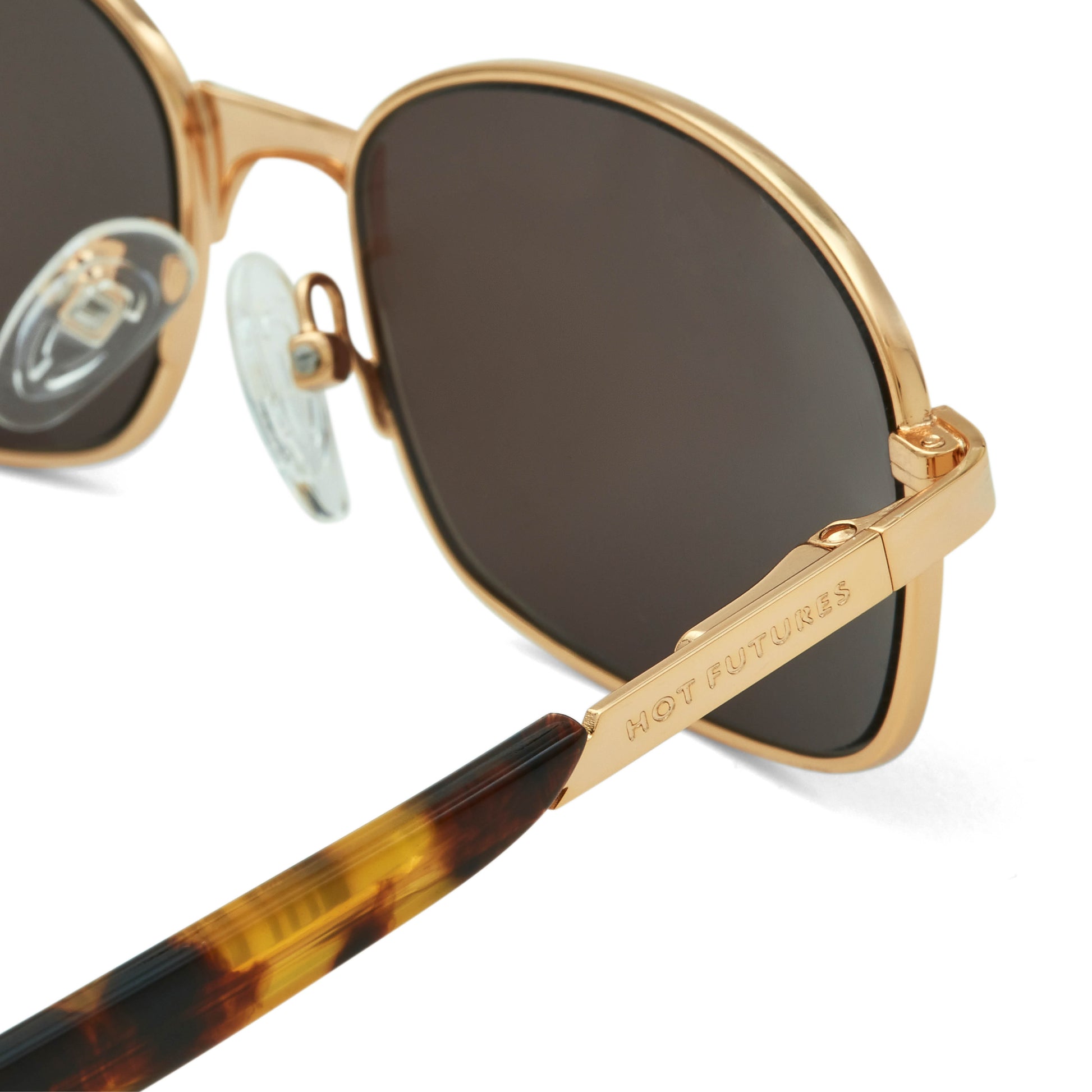 Gold-framed sunglasses with dark lenses on a white background
