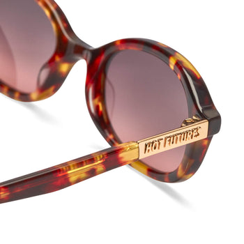 close up shot of the cupid sunglasses in dark tortoiseshell with gold Hot Futures branding
