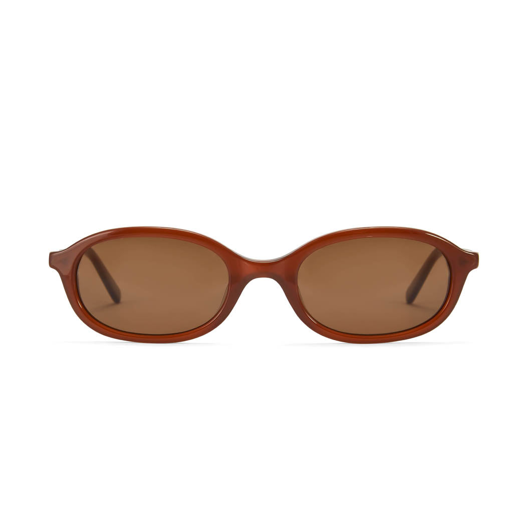 A pair of brown oval sunglasses with gold accents on the arms.