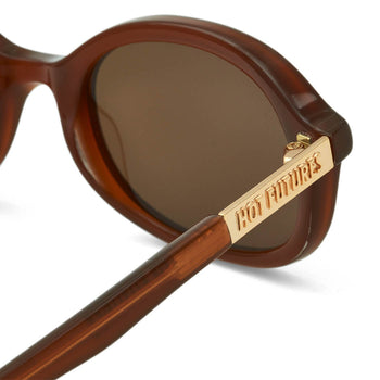 close up shot of the Cupid sunglasses in caramel with the gold Hot Futures branding on the sides, shot against a white background