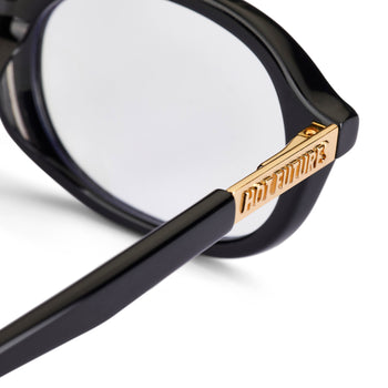 close up shot of the cupid black eye glasses showing the gold hot futures branding on the arm
