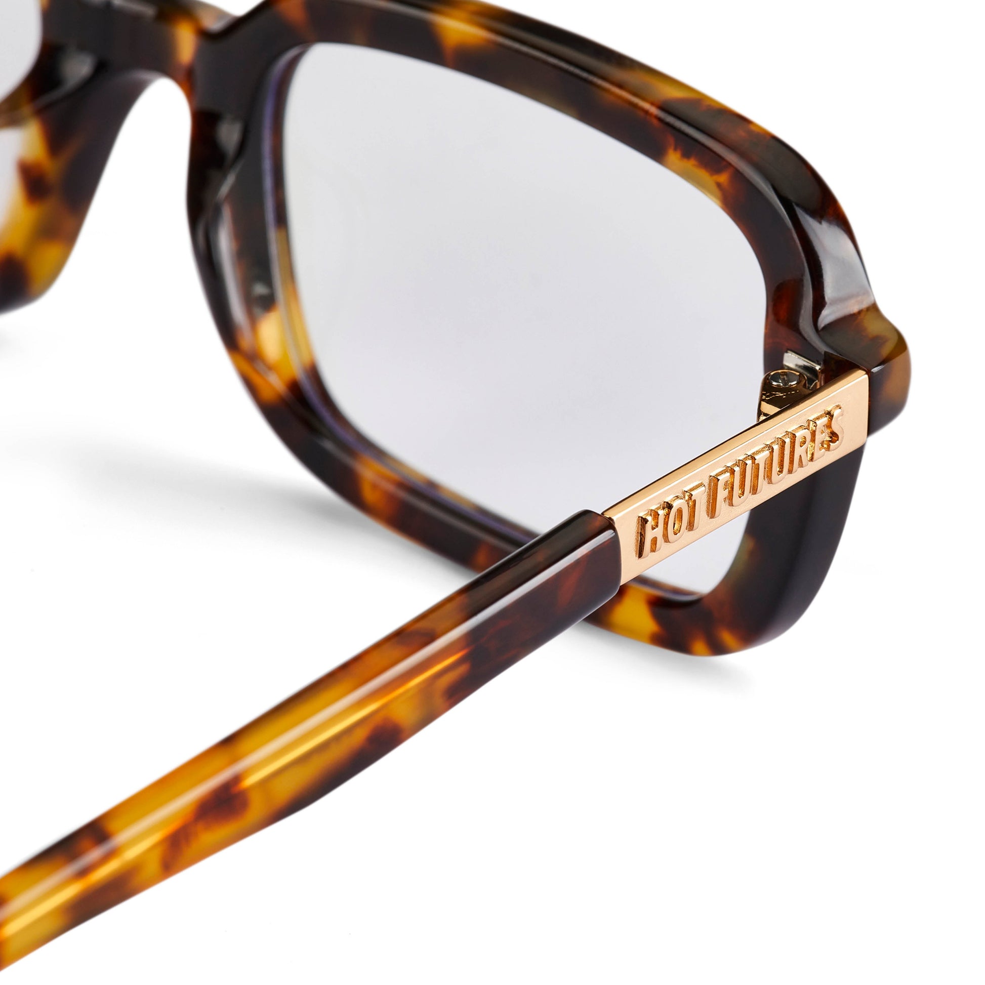 A pair of eyeglasses with a tortoiseshell pattern frame and clear lenses, featuring a Y2K inspired design with a slim rectangle frame.