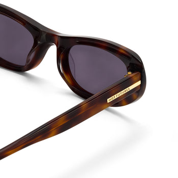 Sunglasses with tortoiseshell frame and dark lenses on a white background