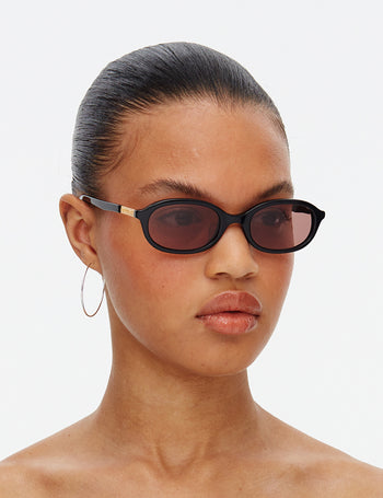 Person wearing black sunglasses with a plain background