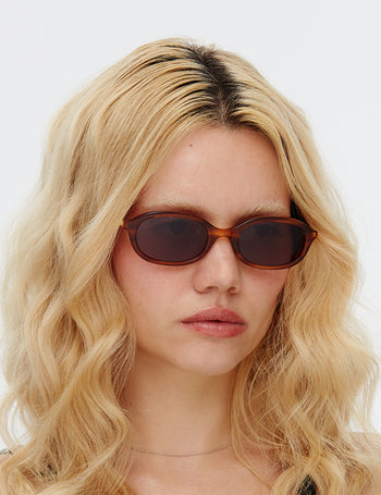 Person wearing sunglasses with a plain background