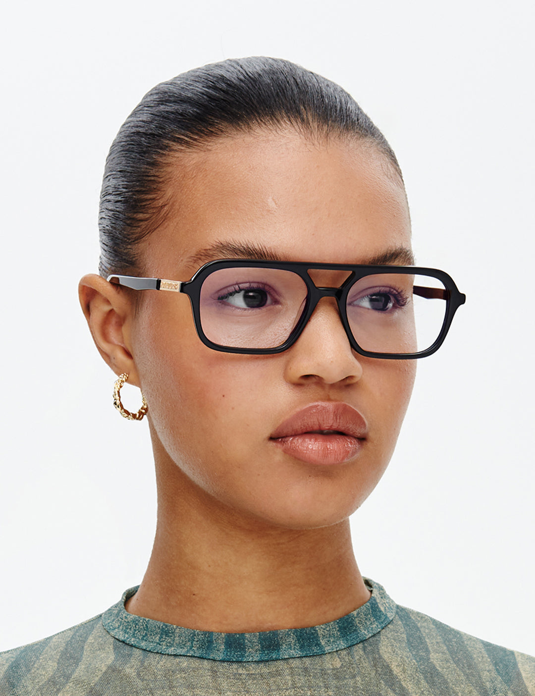 Person wearing black glasses with a neutral background