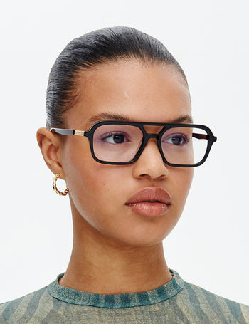 Person wearing black glasses with a neutral background