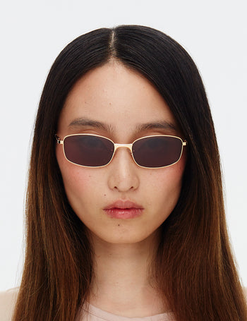 Person wearing sunglasses with a plain background