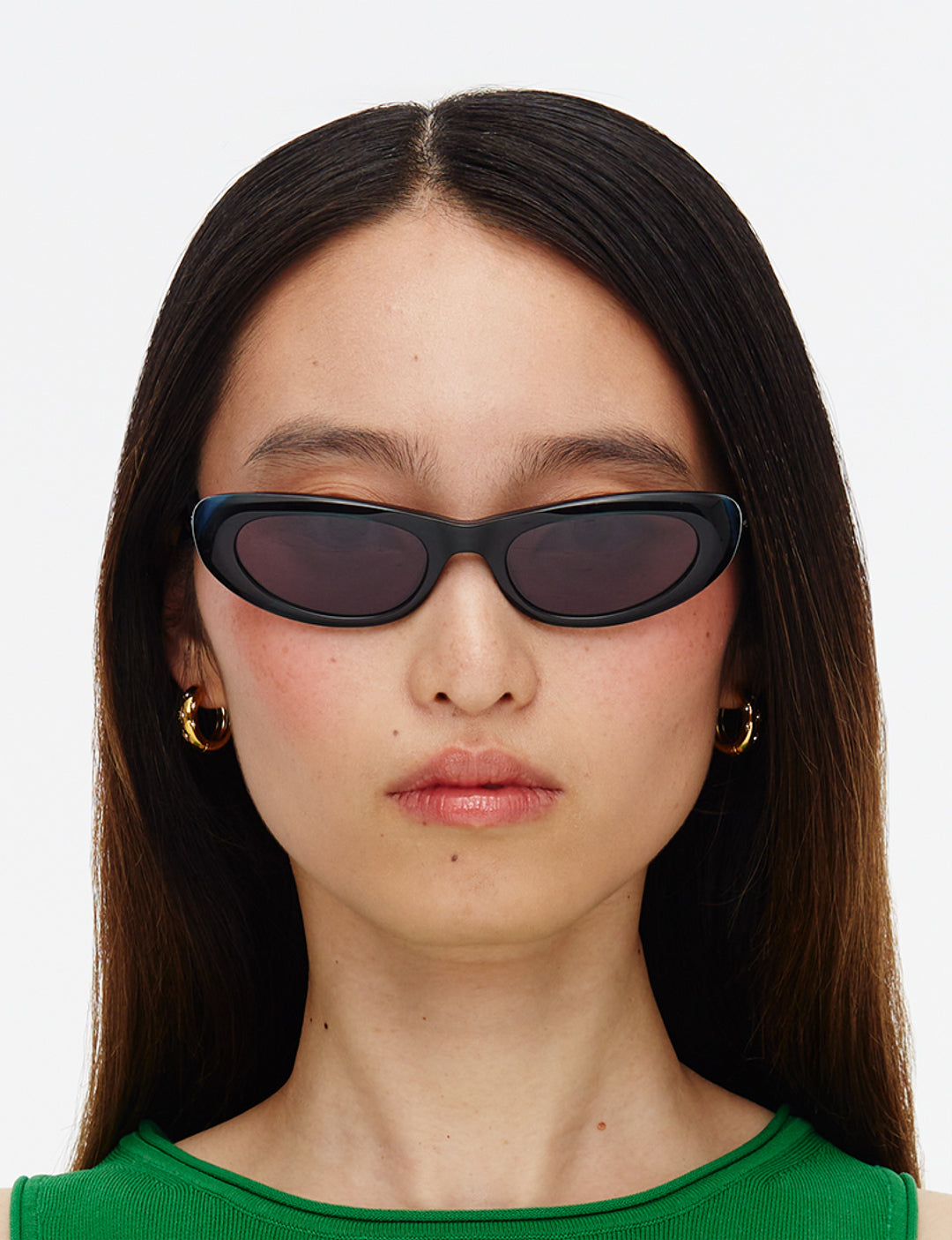 Sunglasses with dark green frames and smoky lenses on a white background