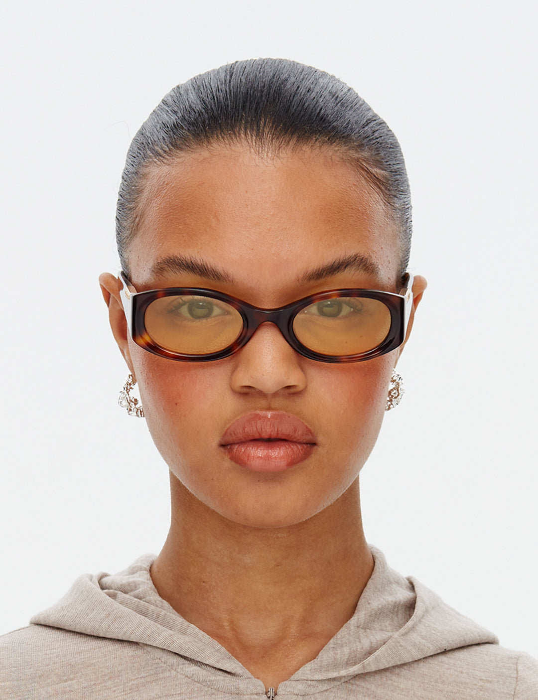 Sunglasses with tortoiseshell frame and yellow lenses on a white background