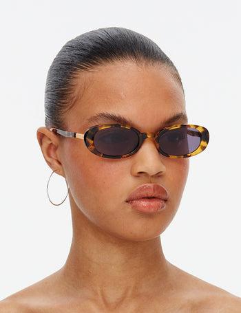 Model wearing Hot Futures tortoiseshell sunglasses with a plain background