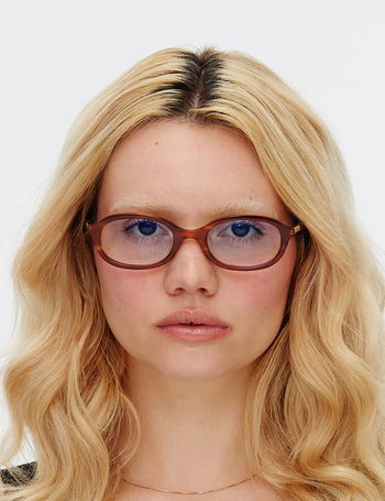 Person with blonde hair and glasses on a white background