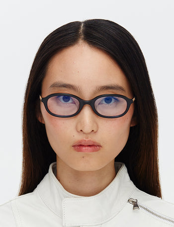 Person wearing black glasses with a plain white background