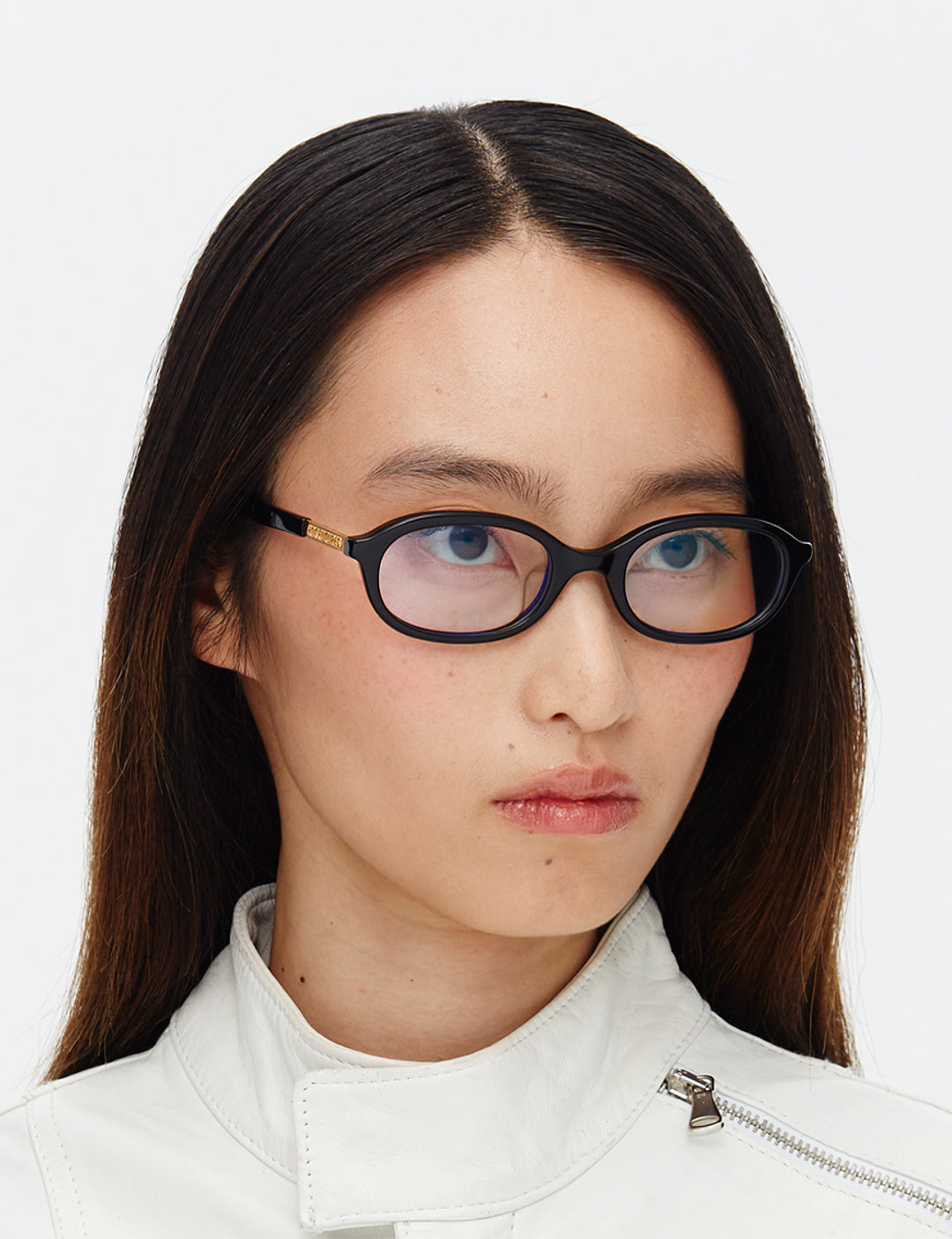 Person wearing black glasses and a white jacket on a white background