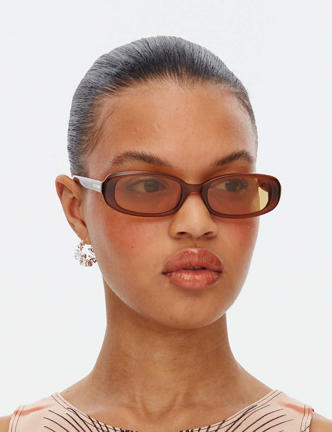 Side angle shot of model wearing the Aurora Brown Gold rectangular sunglasses